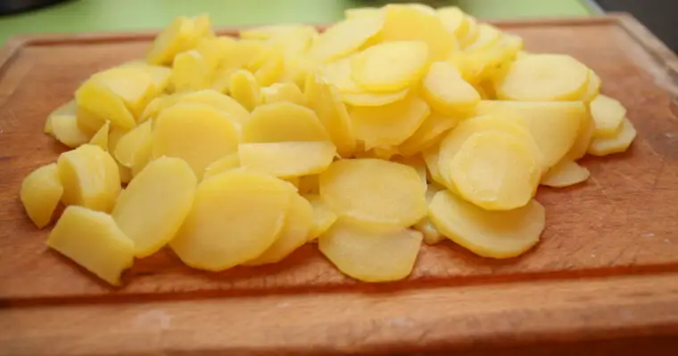 Bratkartoffeln-Rohmasse: Kartoffelscheiben auf einem Schneidebrett